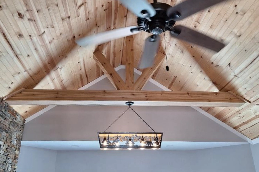 newly installed wooden ceiling and support beam with hanging lights and ceiling fan